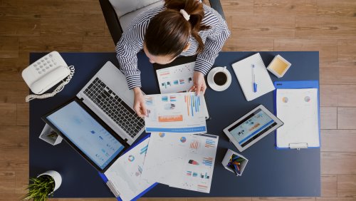 top-view-of-businesswoman-sitting-at-desk-table-checking-financial-accounting-documents-a2c43.jpg